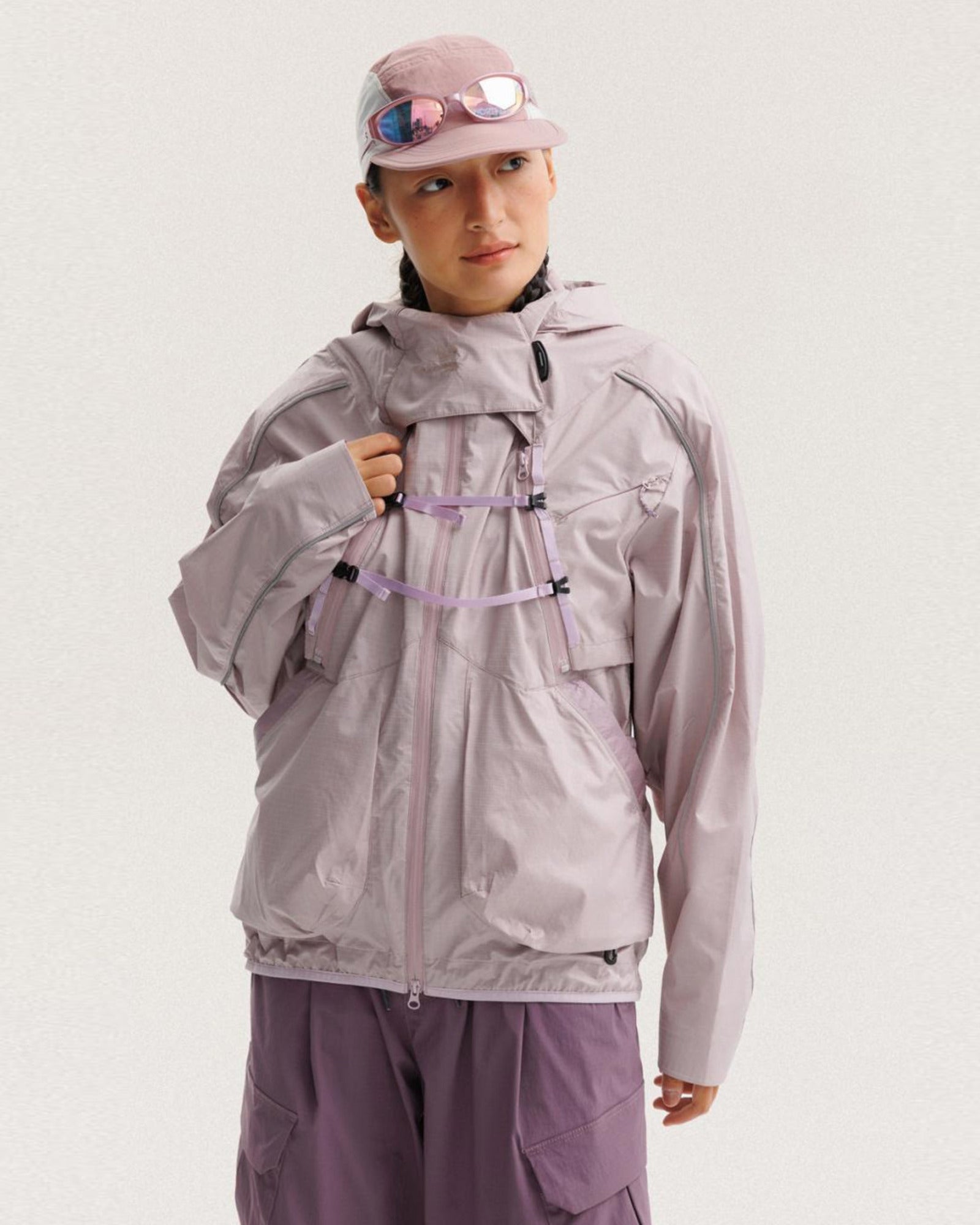 Grapefruit Pink outer shell of the 2-in-1 detachable jacket worn alone by female model, X-webbing buckles and reflective piping, outdoor techwear
