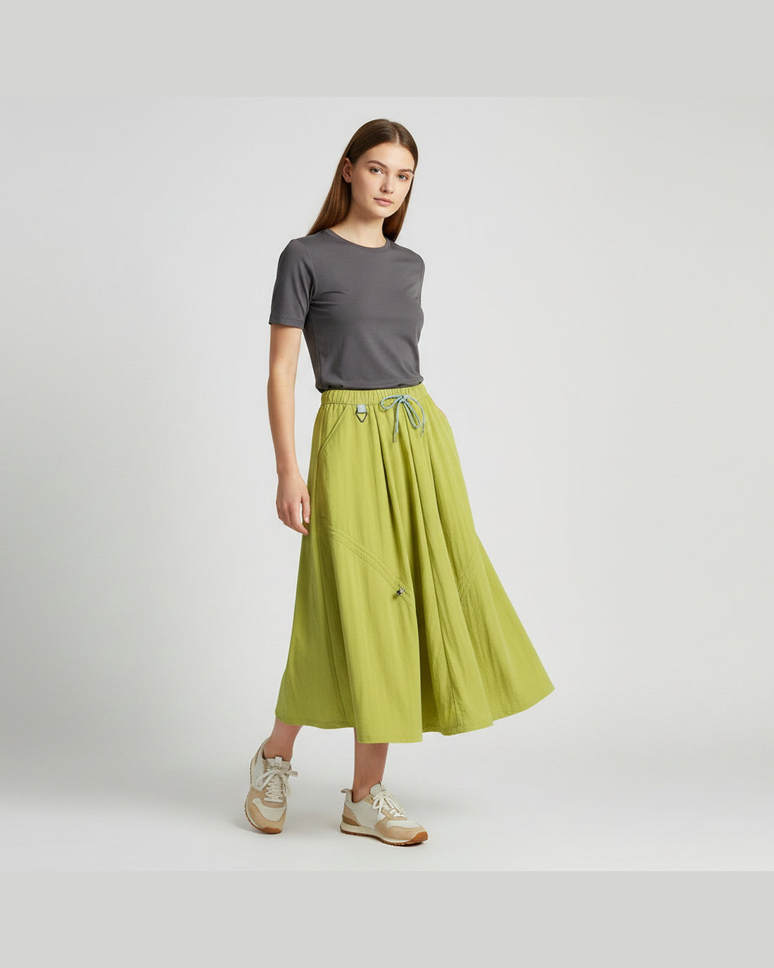 Model wearing lime green technical A-line cargo skirt with adjustable drawstring hem, outdoor gorpcore styling