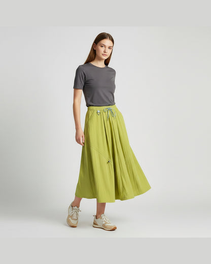 Model wearing lime green technical A-line cargo skirt with adjustable drawstring hem, outdoor gorpcore styling