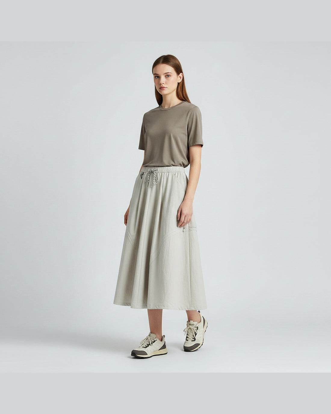 European model in ivory white technical cargo skirt with elastic drawstring waist and flared A-line silhouette