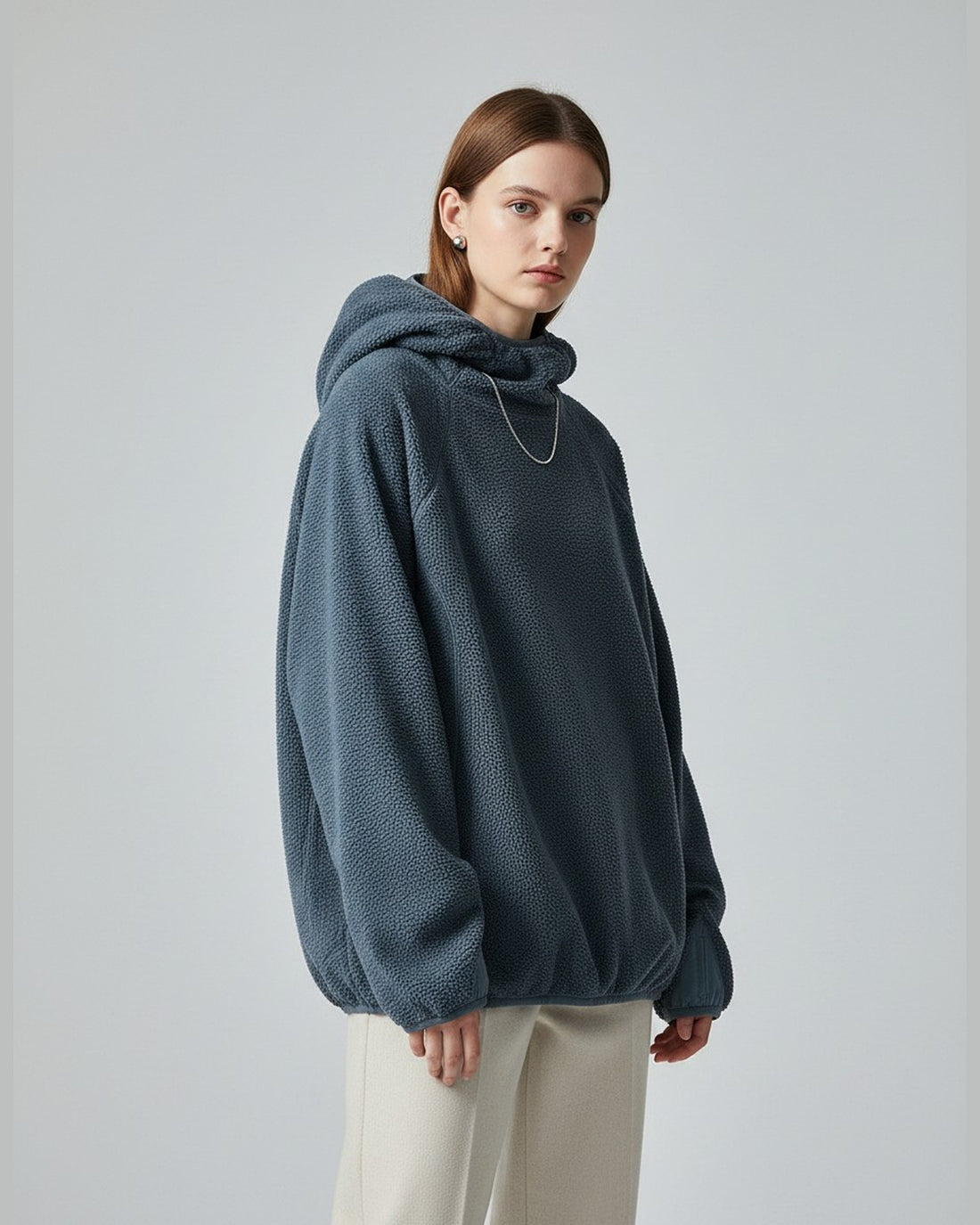 European female model in Skyline Blue plush fleece hoodie, hood up, clean studio e-commerce shot