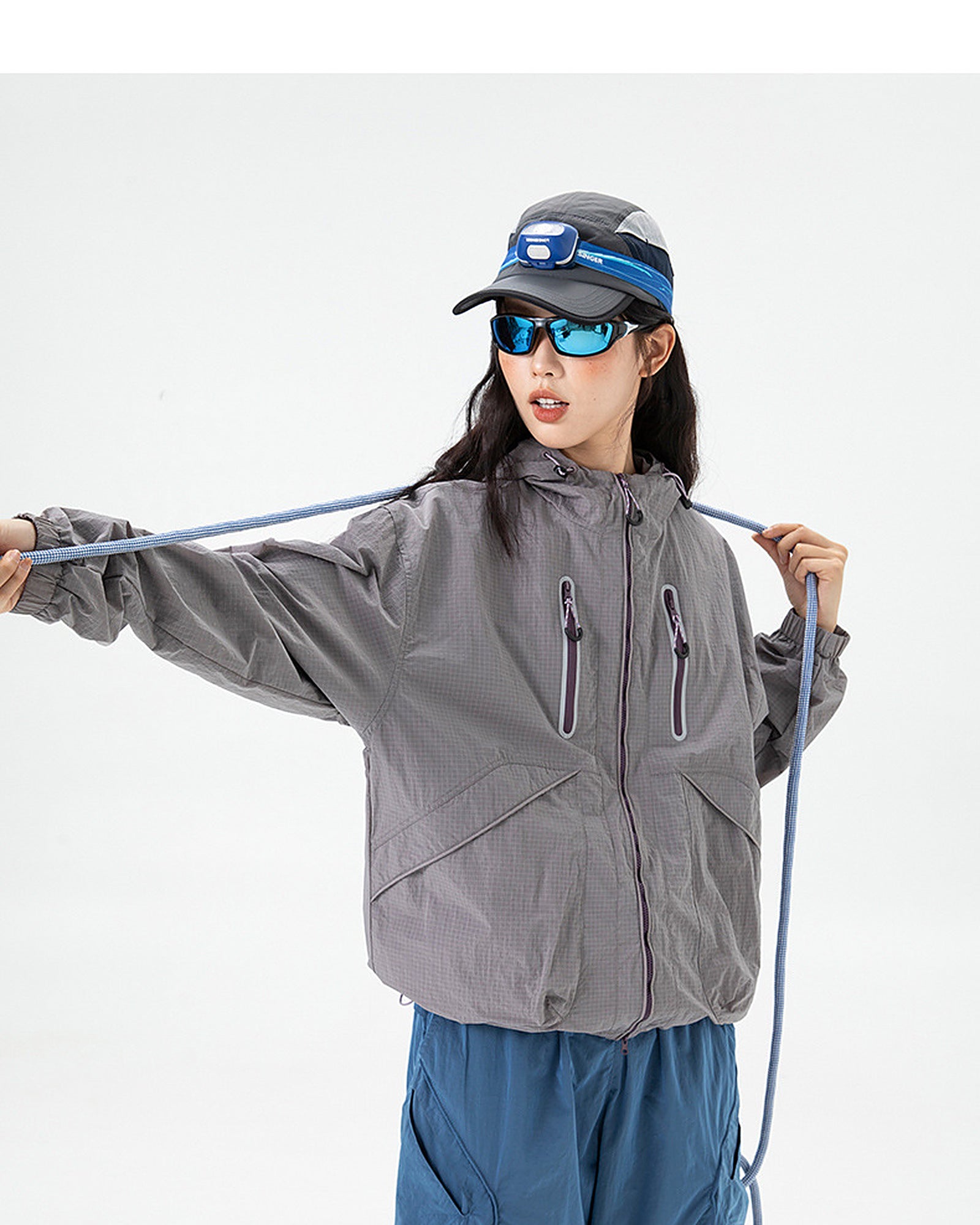 Woman wearing Rose Ash hooded softshell windbreaker jacket with drawcord hood, studio