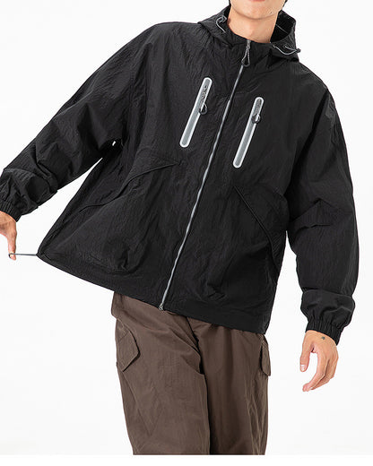 Obsidian Black softshell windbreaker jacket on model, reflective twin chest zip pockets front detail