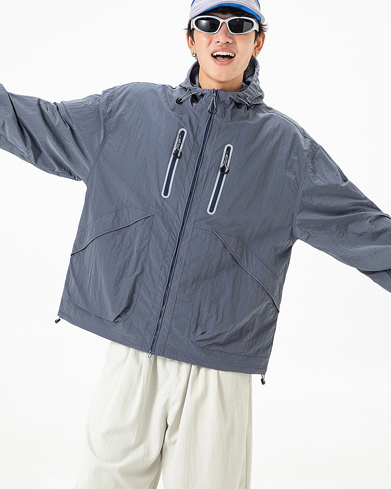 Man wearing Alpine Blue hooded softshell windbreaker jacket, loose oversized fit, studio