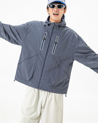 Man wearing Alpine Blue hooded softshell windbreaker jacket, loose oversized fit, studio