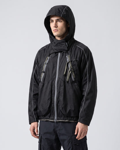 Midnight Black 2-in-1 detachable hooded shell jacket on young European male model, hood up, showing X-webbing chest buckles and reflective piping, clean studio techwear