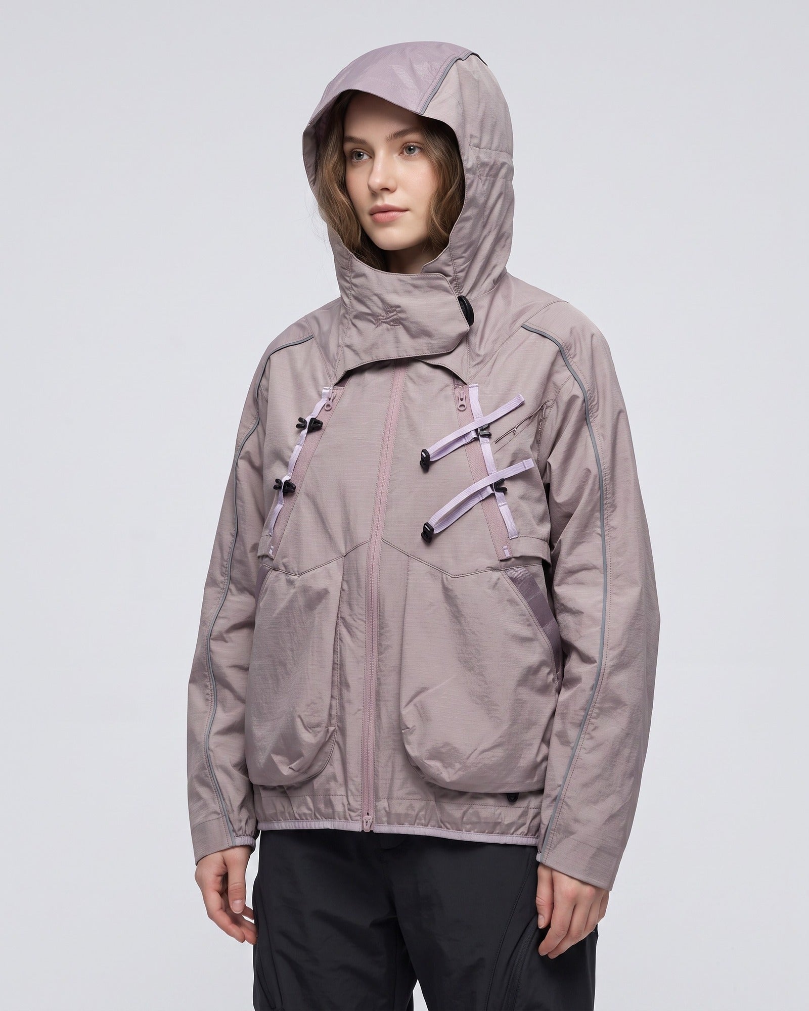 Grapefruit Pink 2-in-1 detachable hooded shell jacket on young European female model, dusty mauve-pink techwear, reflective piping studio