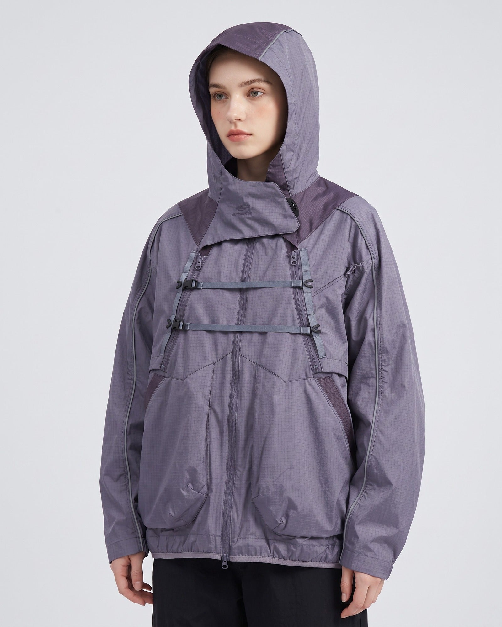 Mist Lavender 2-in-1 detachable hooded shell jacket on female model, muted slate-purple techwear with X-webbing chest buckles, studio