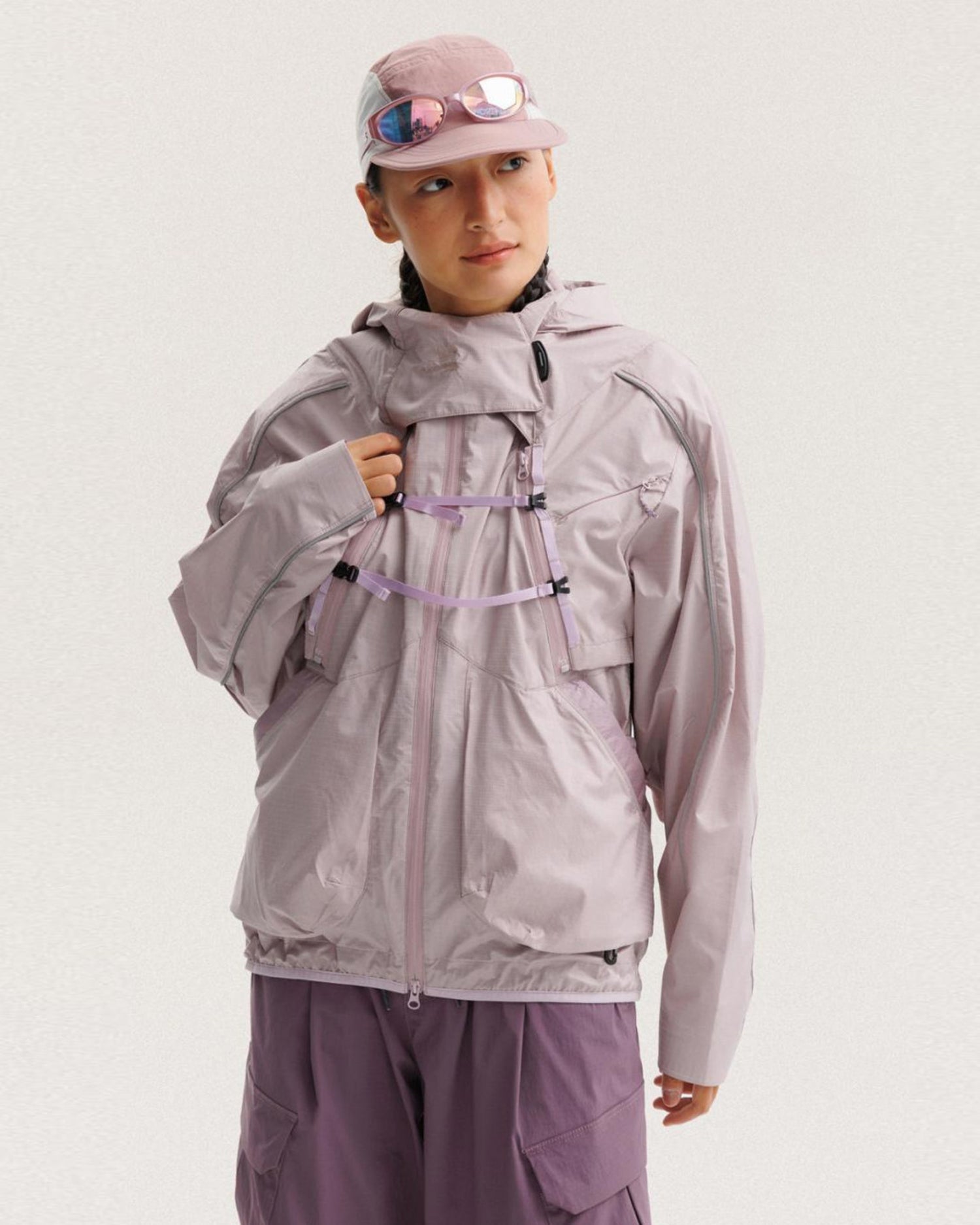 Grapefruit Pink outer shell of the 2-in-1 detachable jacket worn alone by female model, X-webbing buckles and reflective piping, outdoor techwear